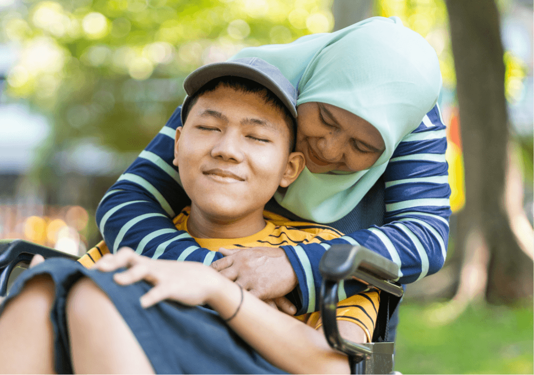 A caregiver hugging a child who is smiling